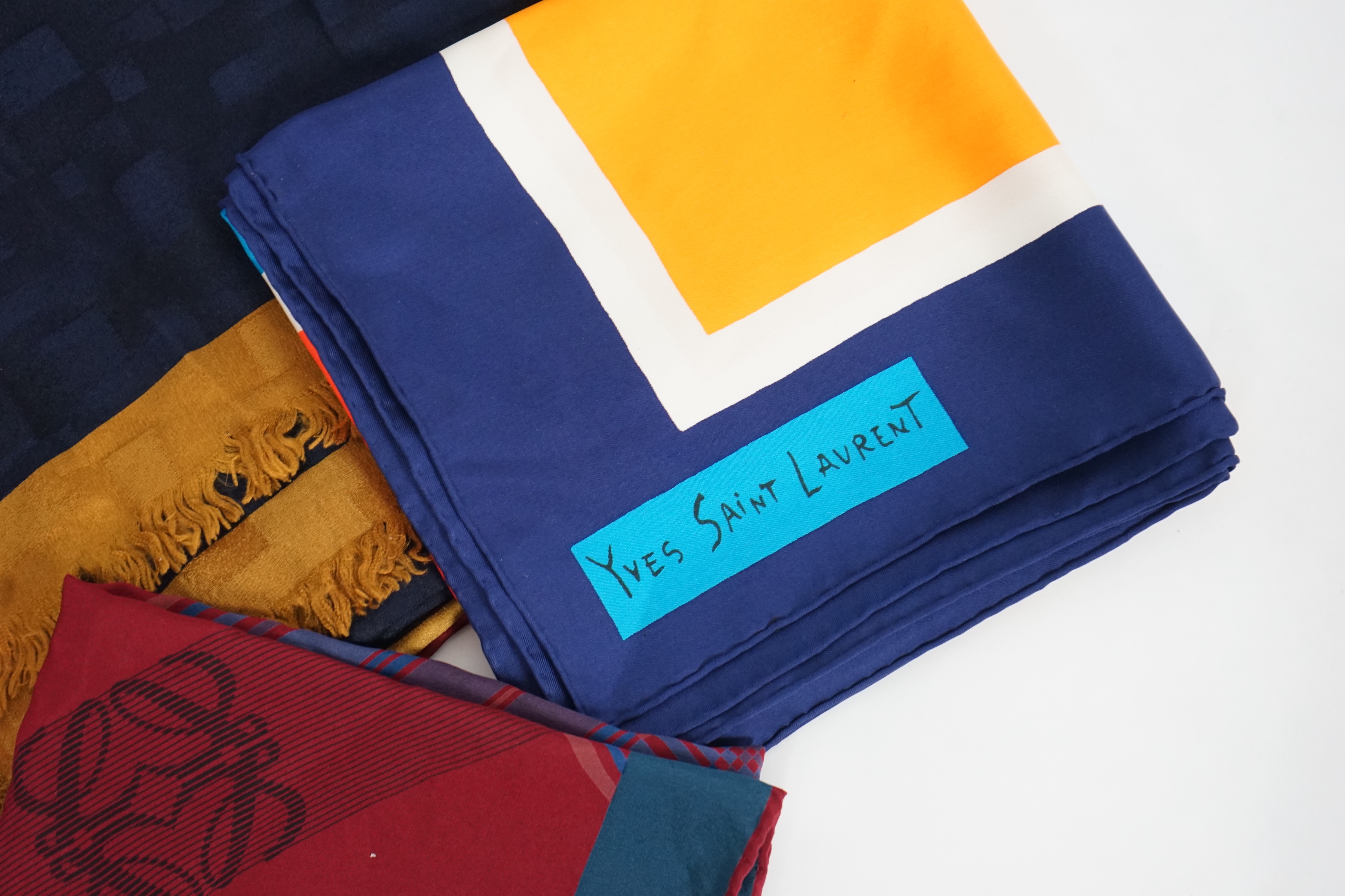 A selection of Yves Saint Laurent, two Christian Dior, Richel and Loewe silk scarves, YSL, 83cm x 85cm Christian Dior: 84cm x 80cm Richel: 87cm x 87cm Loewe: 86cm x 82cm Christian Dior large scarf 120cm x 130cm approx.